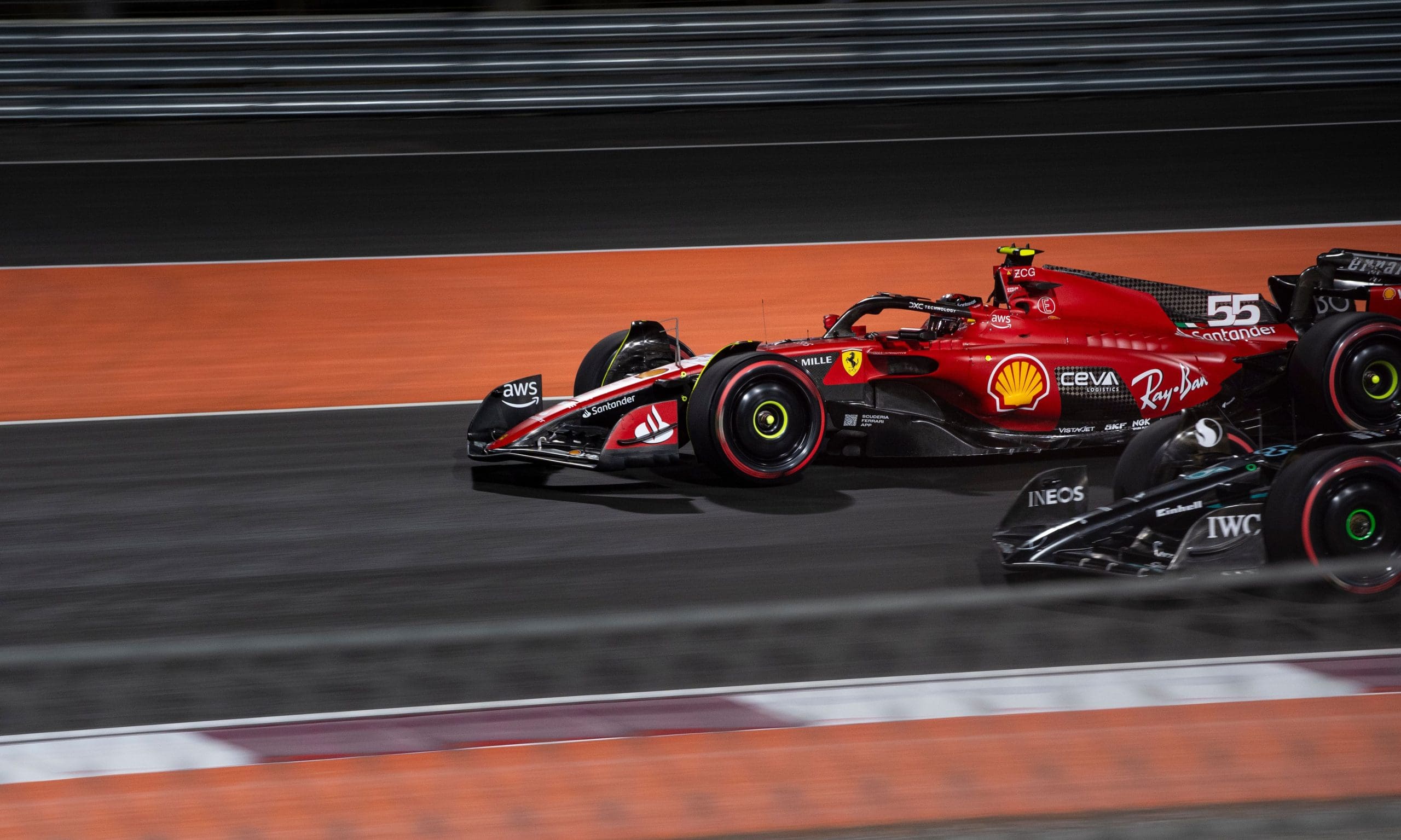 Two Formula 1 Cars Racing On Track